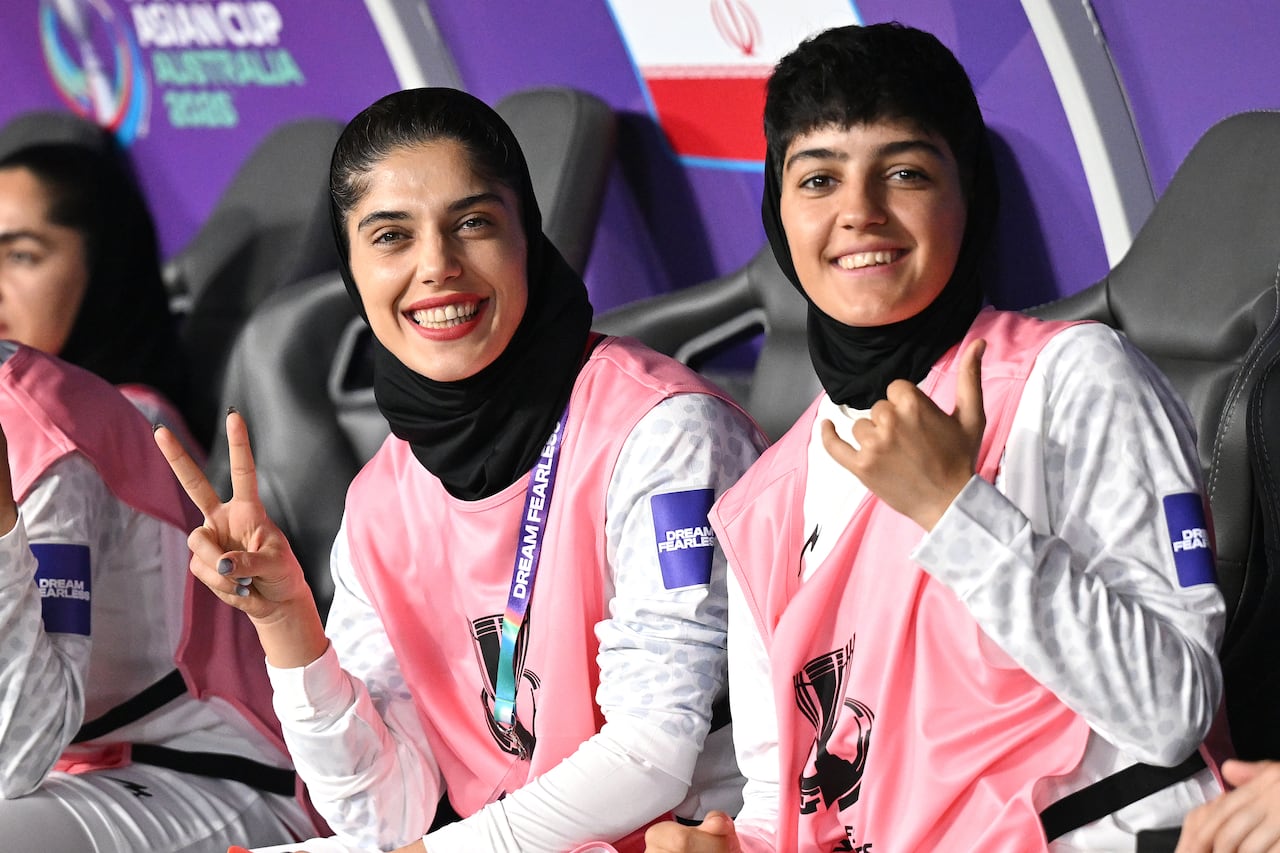 Iranian soccer players smile at the camera.