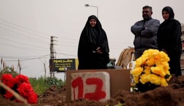 Mourners bury the dead at a temporary cemetery by the side of a road in Tyre