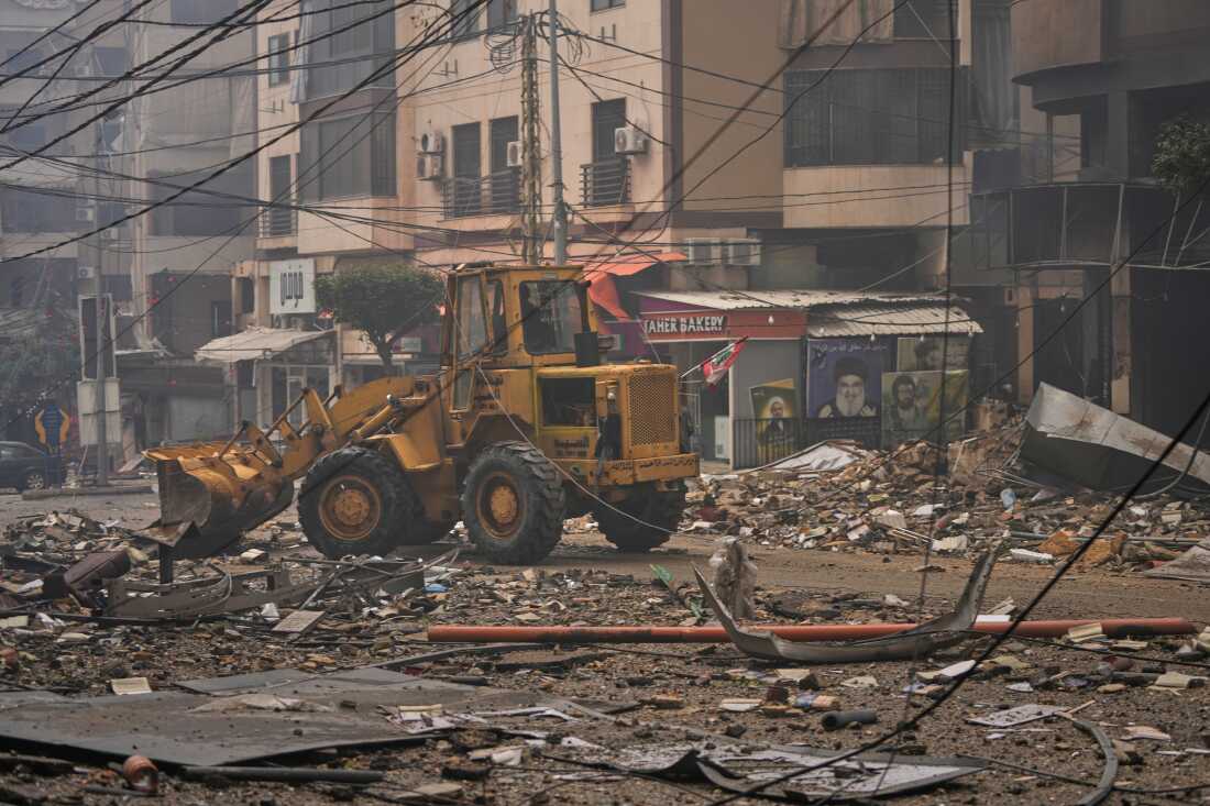A bulldozer clears debris from the rubble of buildings destroyed in an Israeli airstrike in Dahiyeh, Beirut's southern suburbs, Lebanon, Sunday, March 15, 2026.