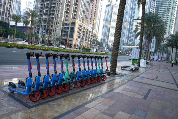 Electric scooters are parked on a sidewalk in downtown Dubai, United Arab Emirates, Saturday, March 7, 2026. (AP Photo/ Fatima Shbair)