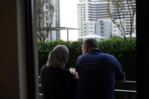 Palestinians who traveled to South Africa via a charter flight organized by an Israeli group whose founder supported U.S. President Donald Trump's proposal to resettle Palestinians from Gaza stand in their temporary flat in Johannesburg, South Africa, Wednesday, Feb. 4, 2026. (AP Photo/Jerome Delay)
