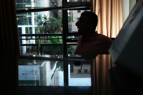 A Palestinian man who traveled to South Africa via a charter flight organized by an Israeli group whose founder supported U.S. President Donald Trump's proposal to resettle Palestinians from Gaza sits in his temporary flat in Johannesburg, South Africa, Wednesday, Feb. 4, 2026. (AP Photo/Jerome Delay)