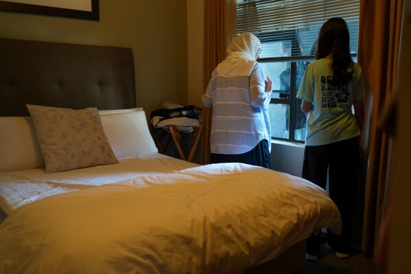 Palestinians who traveled to South Africa via a charter flight organized by an Israeli group whose founder supported U.S. President Donald Trump's proposal to resettle Palestinians from Gaza stand in their temporary flat in Johannesburg, South Africa, Wednesday, Feb. 4, 2026. (AP Photo/Jerome Delay)