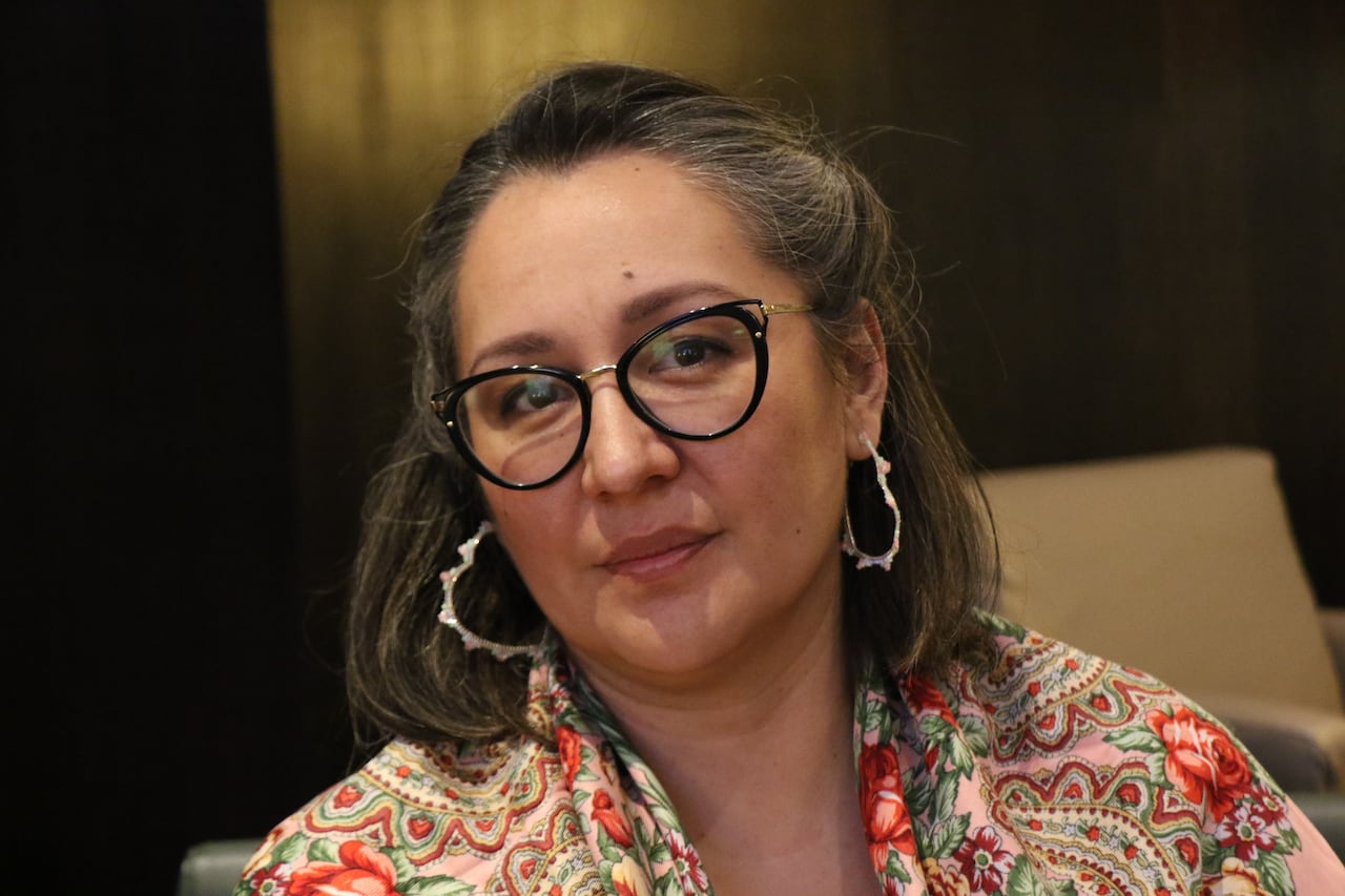 A Cree woman looks directly at the camera with a flowered shall.