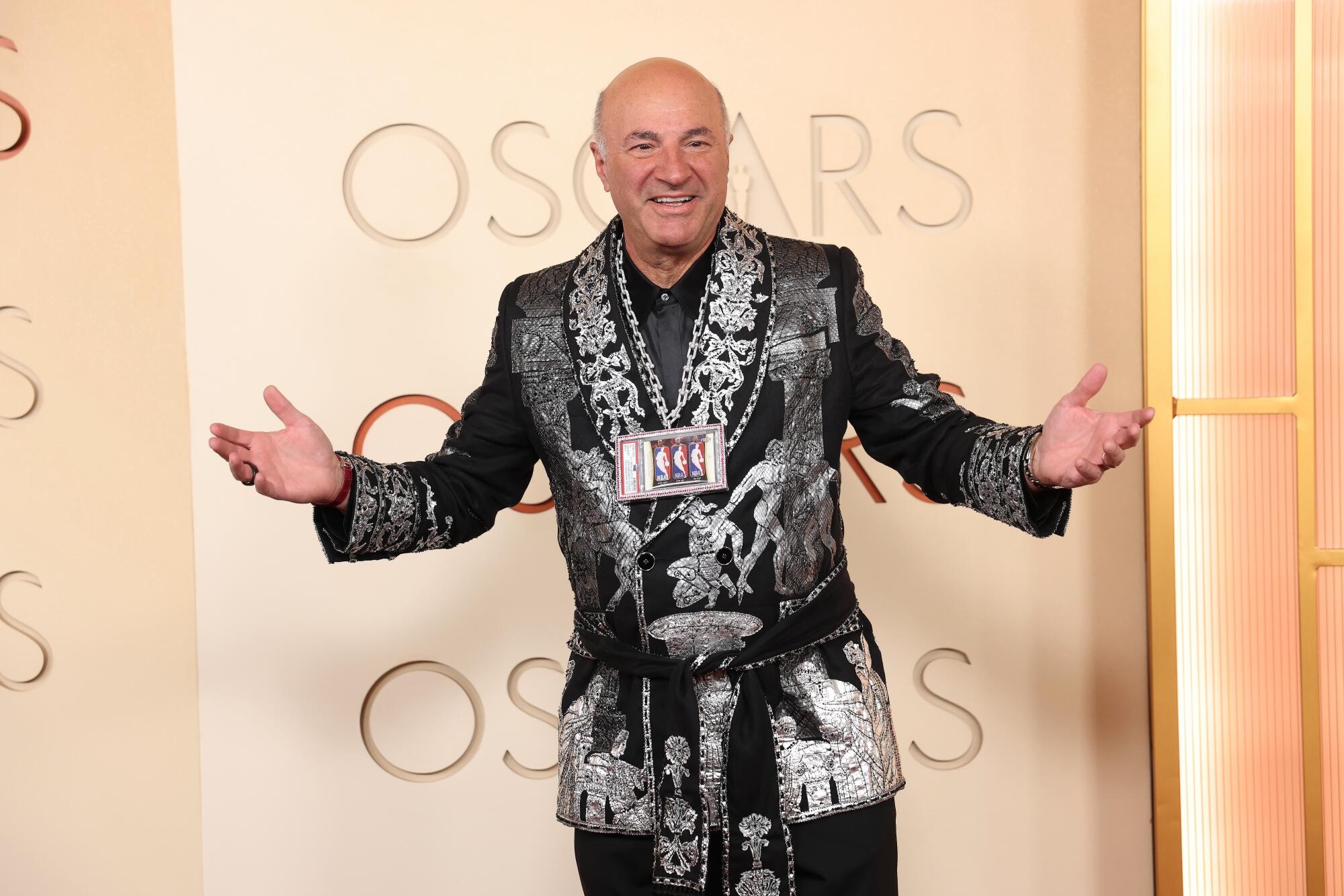 Kevin O'Leary, wearing a smoking jacket, poses on the red carpet. 