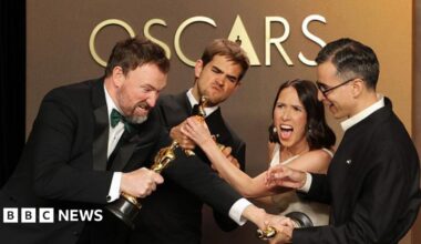 The four film-makers playfully pretend to fight over their Oscars statues.