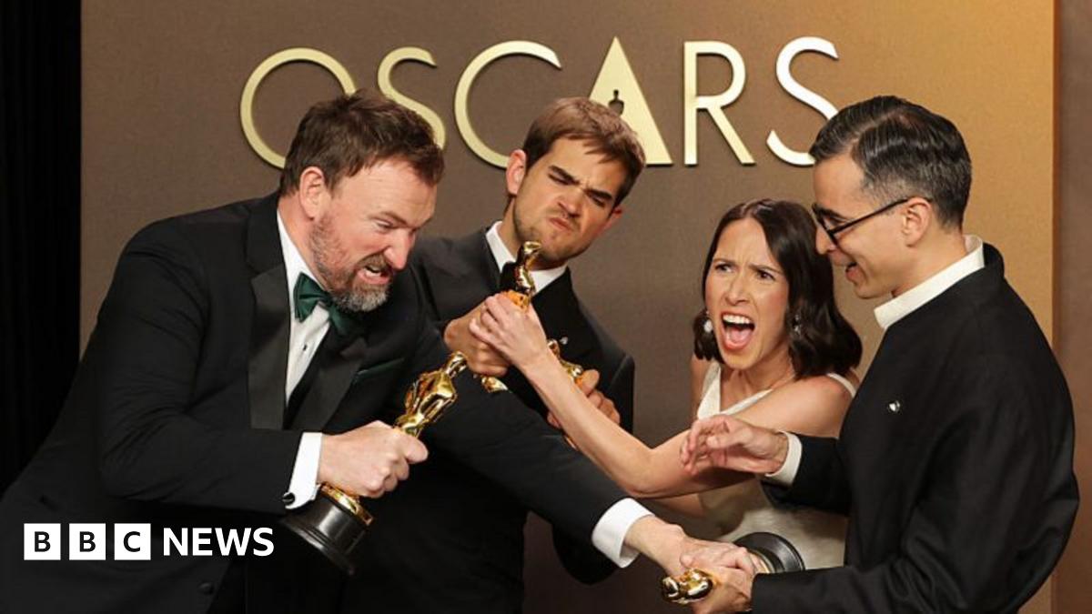 The four film-makers playfully pretend to fight over their Oscars statues.