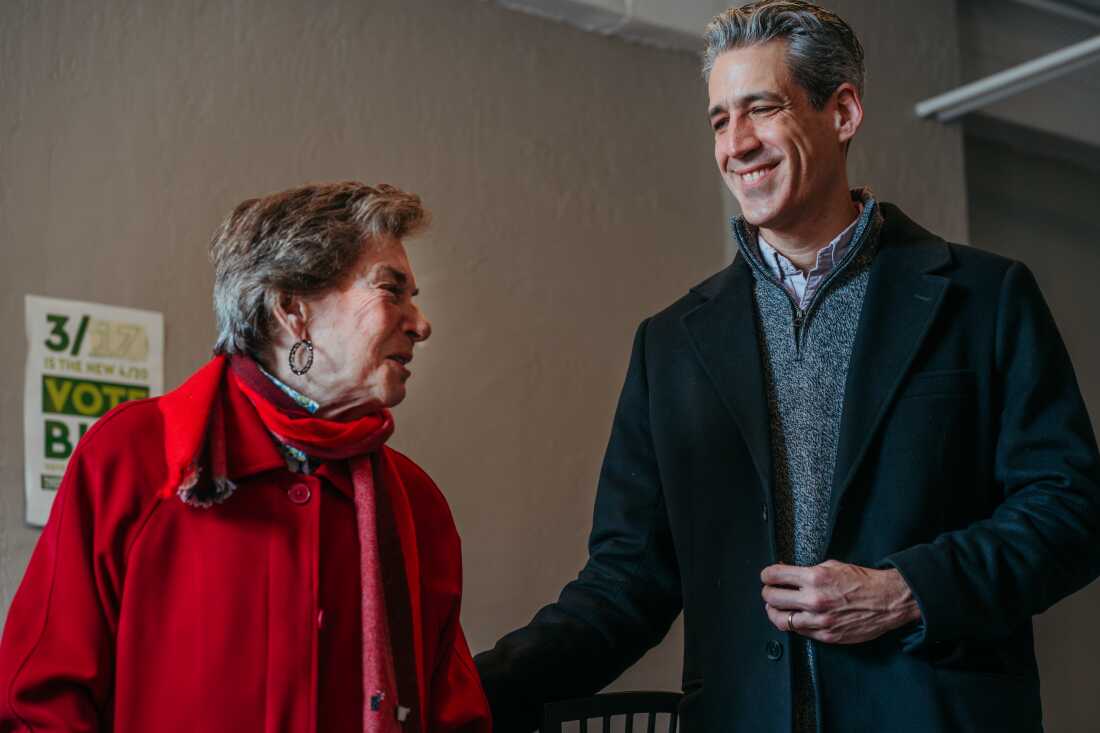 U.S. Rep. Jan Schakowsky stands alongside Evanston Mayor Daniel Biss as he addresses volunteers at his campaign office while running in the Democratic primary for Illinois’ 9th Congressional District on February 28, 2026, in Evanston, Illinois. Biss is seeking the Democratic nomination for the open seat in the March 17, 2026 primary election. Schakowsky, who is retiring from Congress, has endorsed Biss in the race. Jamie Kelter Davis for NPR