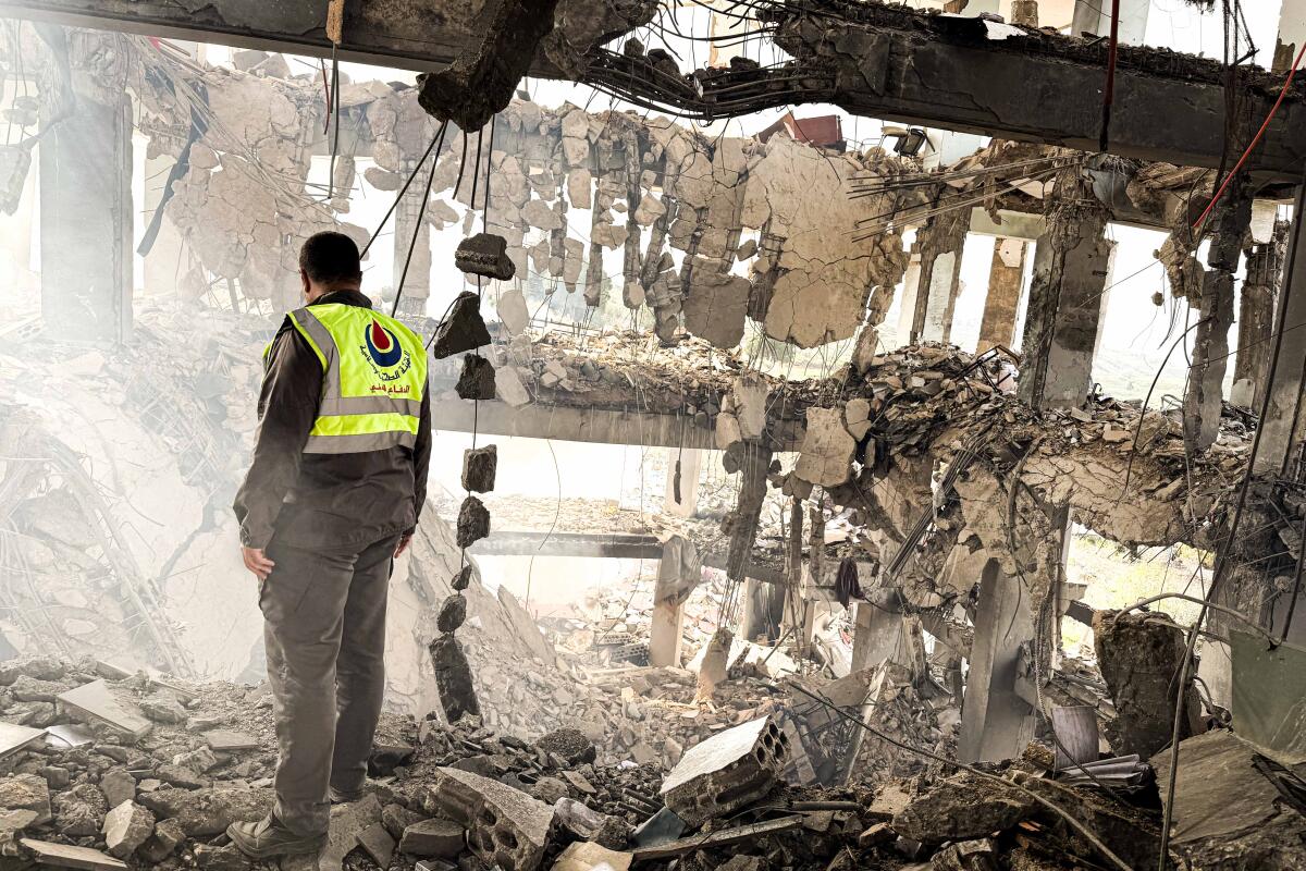 Abdullah Nour Al-Din looks at the rubble at Borj Qalaouiyah Heathcare Center 