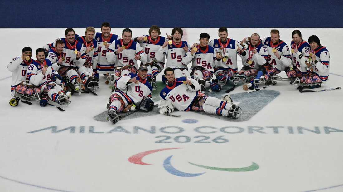 The U.S. men's sled hockey team players celebrate with the gold medals after the ice hockey match between USA' and Canada at the Milano Cortina 2026 Paralympic Winter Games in Milan on March 15, 2026. (Photo by Stefano RELLANDINI / AFP via Getty Images)