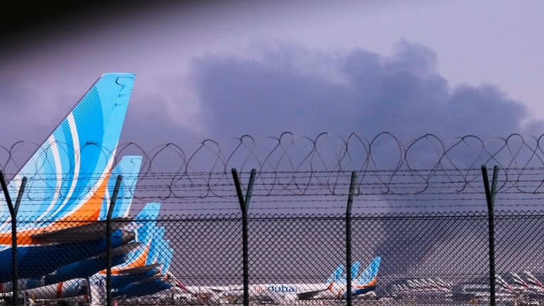 FlyDubai planeS is parked at Dubai International Airport as smoke...