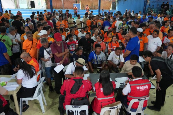 Tricycle drivers prepare their documents to receive their cash assistance from the government to help in their livelihood as oil prices continue to rise on Tuesday, March 17, 2026, in Manila, Philippines. (AP Photo/Aaron Favila)