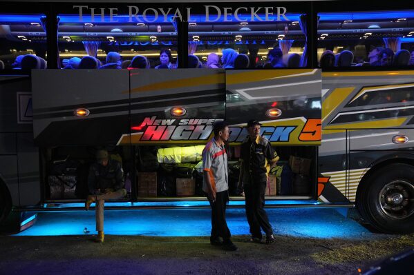 Bus crew wait for passengers as the mass exodus out of Jakarta and other major cities is underway ahead of Eid al-Fitr in Jakarta, Indonesia, Tuesday, March 17, 2026. (AP Photo/Dita Alangkara)