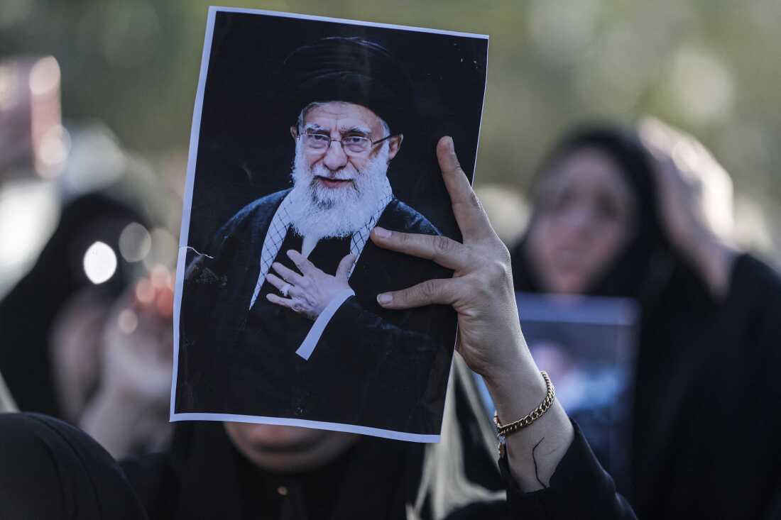 An Iraqi Shiite Muslim woman holds up the image of killed Iranian supreme leader Ayatollah Ali Khamenei, during a symbolic funeral the day after his assassination, in the district of Sadr City, in Baghdad on March 1, 2026. (Photo by AHMAD AL-RUBAYE / AFP via Getty Images)