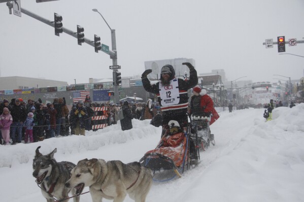 Musher Keaton Loebrich of Fairbanks, Alaska, encourages applause from the crowd as he drives his dog team down Fourth Avenue in downtown Anchorage, Alaska, on Saturday, March 7, 2026, during the ceremonial start of the Iditarod Trail Sled Dog Race. (AP Photo/Mark Thiessen)