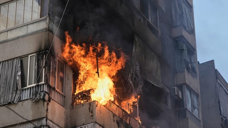Smoke and flame rise from a residential building following an...