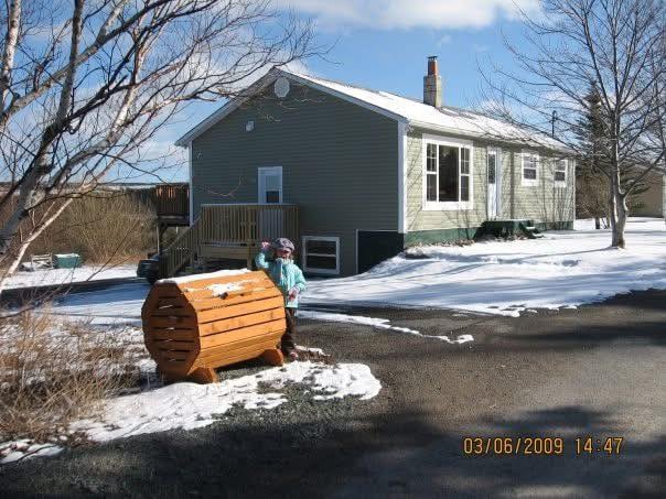 A young girl stands in front of a house.