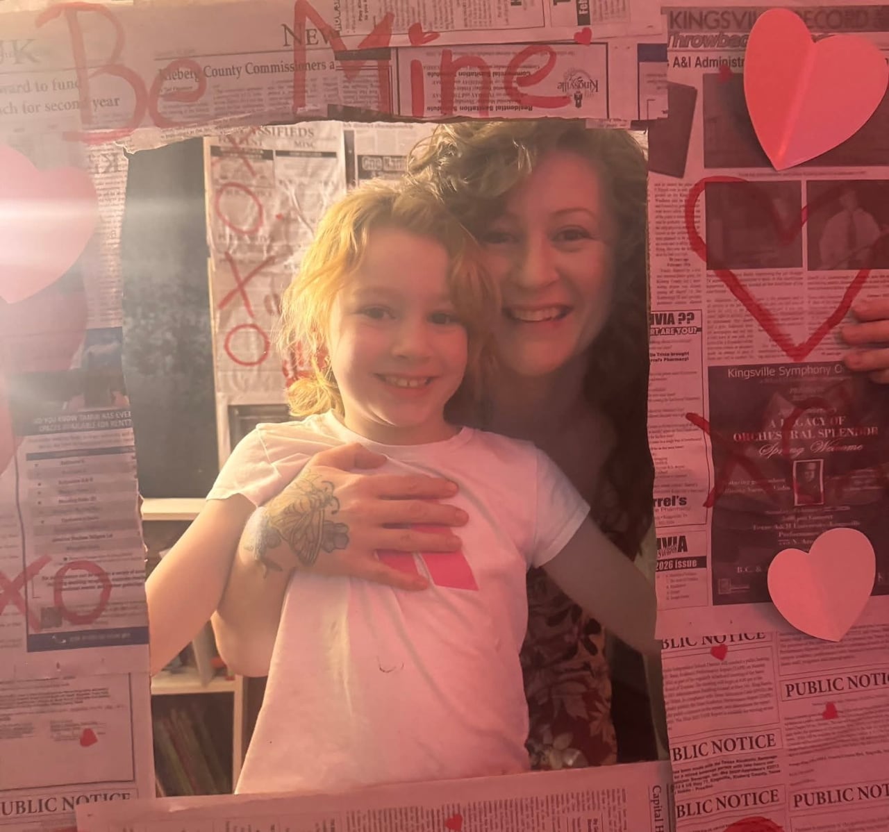A picture of a mother and child stuck on a wall of newspapers.