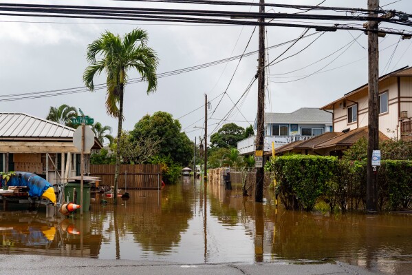 Streets are flooded from severe rains, Friday, March 20, 2026, in Haleiwa, Hawaii. (AP Photo/Mengshin Lin)
