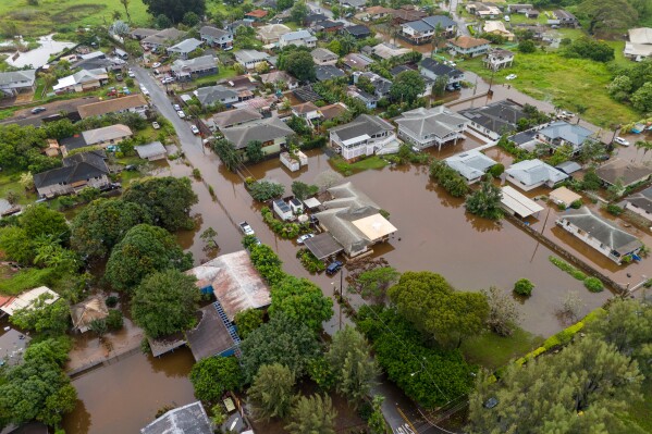 Streets are flooded from severe rains, Friday, March 20, 2026, in Haleiwa, Hawaii. (AP Photo/Mengshin Lin)