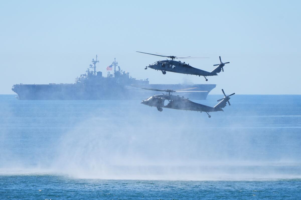 Marines perform a demonstration with helicopters and the amphibious assault ship USS Boxer