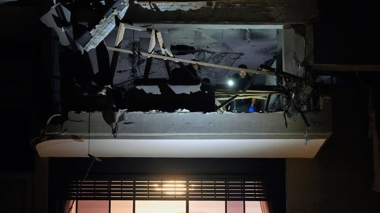 Israeli security forces inspect an apartment struck by an Iranian...