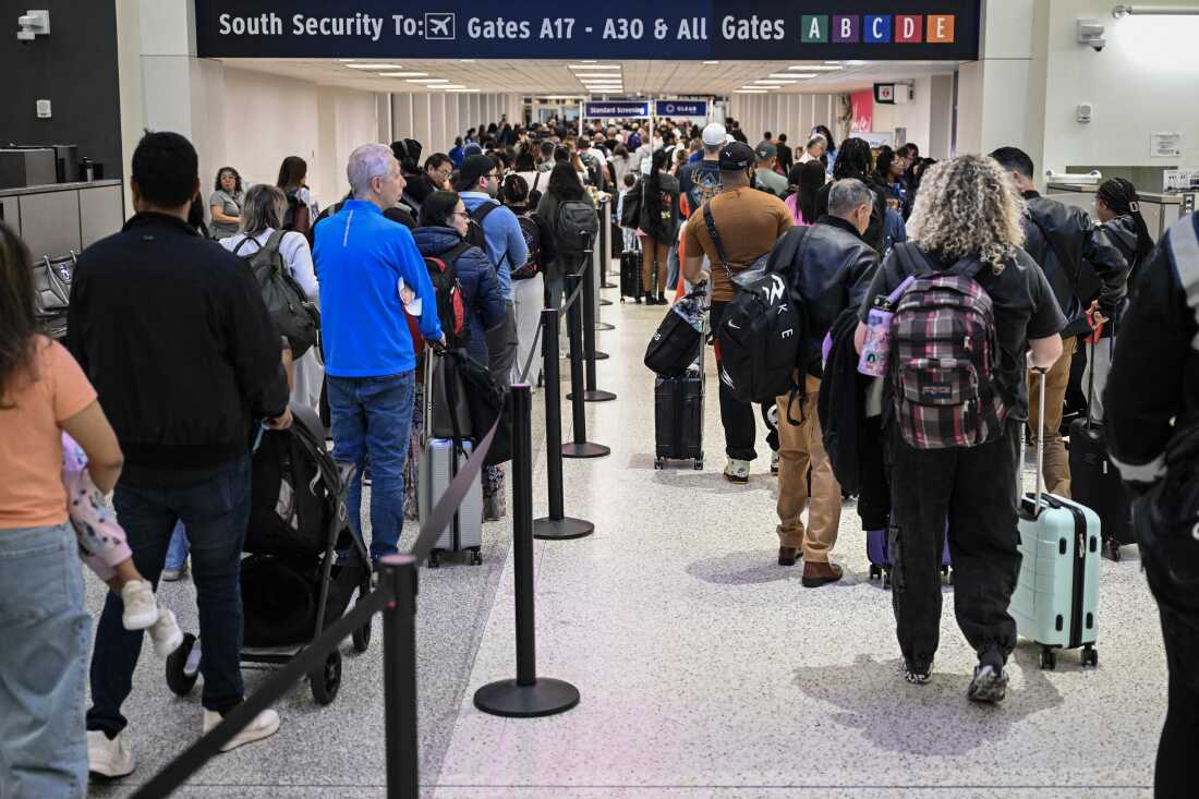 Travelers wait in line at a TSA security checkpoint at George Bush Intercontinental Airport in Houston, Texas, on March 20, 2026.