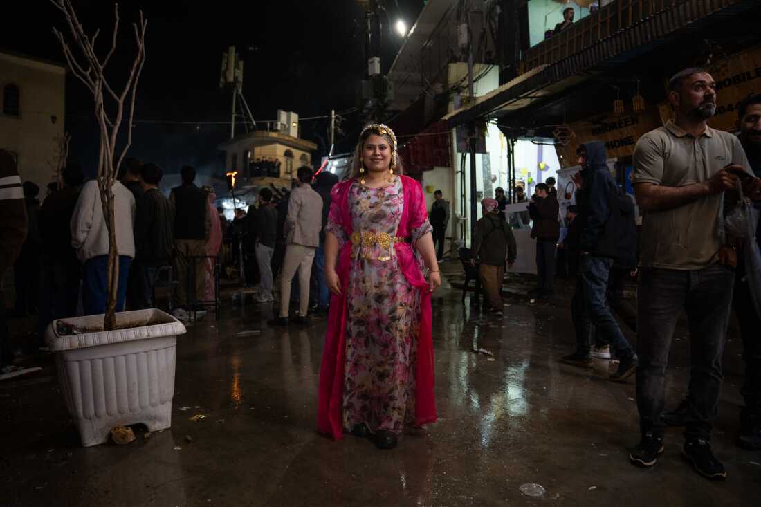 Arastah (CQing name), 27, visits Akre for Nowruz. She is wearing a pink floral gown and a headpiece over her long hair.