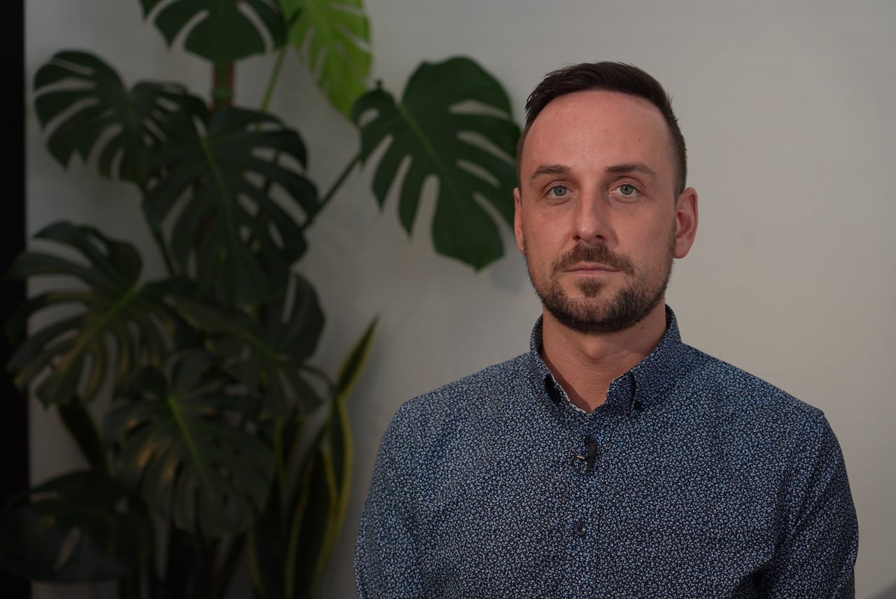 Image of a man wearing a blue button-up shirt