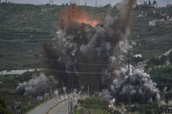 Smoke and flames rise from an Israeli airstrike that hit the Qasmiyeh Bridge near the coastal city of Tyre, Lebanon, Sunday, March 22, 2026. (AP Photo/Mohammad Zaatari)