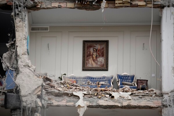 Rubble covers the furniture of a destroyed living room in a residential building hit in an earlier U.S.-Israeli strike in Tehran, Iran, Monday, March 23, 2026. (AP Photo/Vahid Salemi)