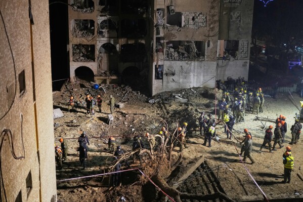 Israeli security forces and rescue teams work at the site struck by an Iranian missile in Arad, southern Israel, Sunday, March 22, 2026. (AP Photo/Ohad Zwigenberg)