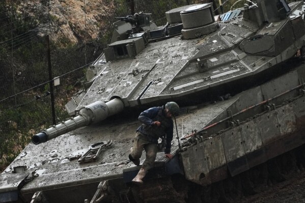An Israeli soldier jumps from a tank in northern Israel near the border with Lebanon, Saturday, March 21, 2026. (AP Photo/Ariel Schalit)
