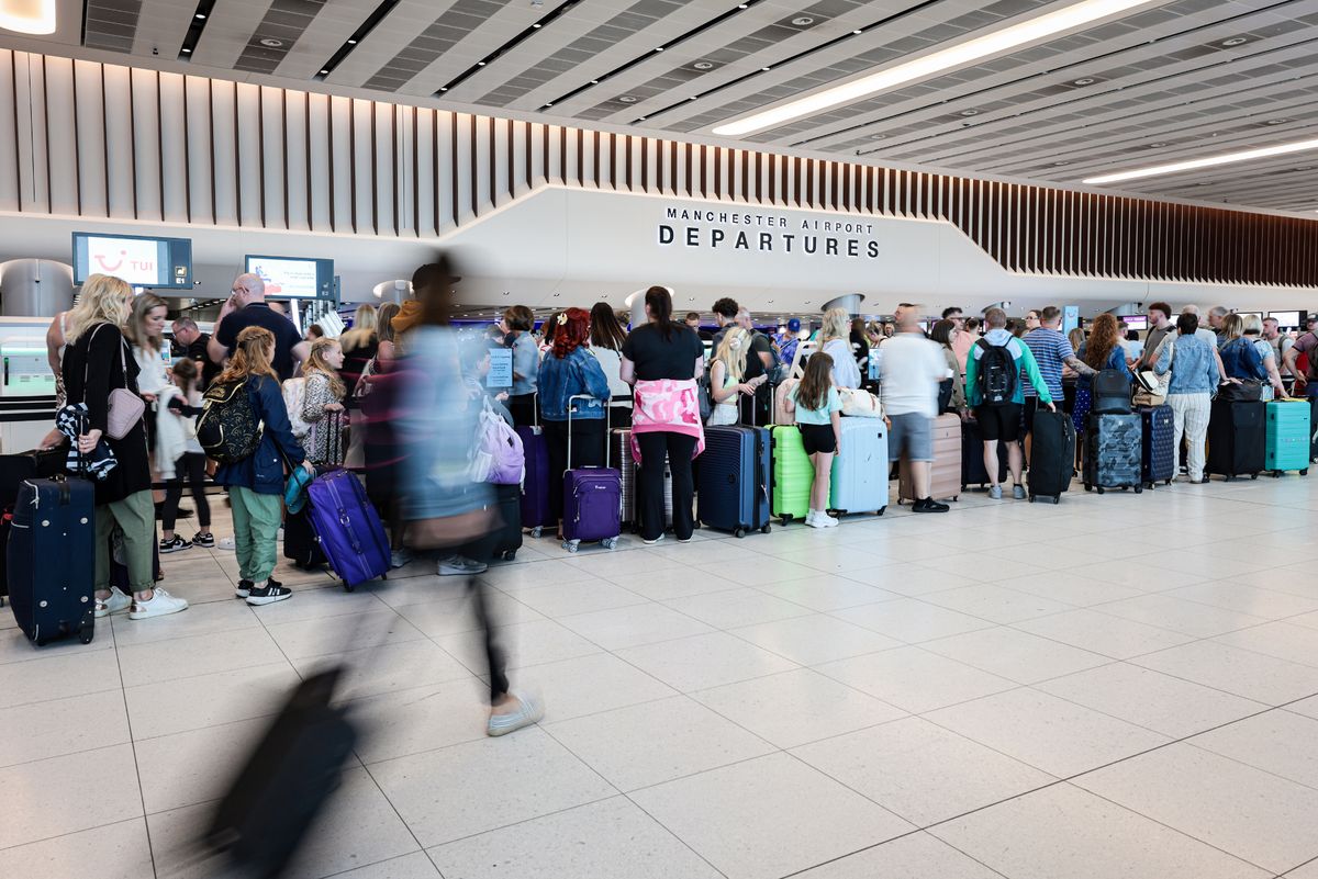 Terminal 2, Manchester Airport Departures with people walking with suitcases