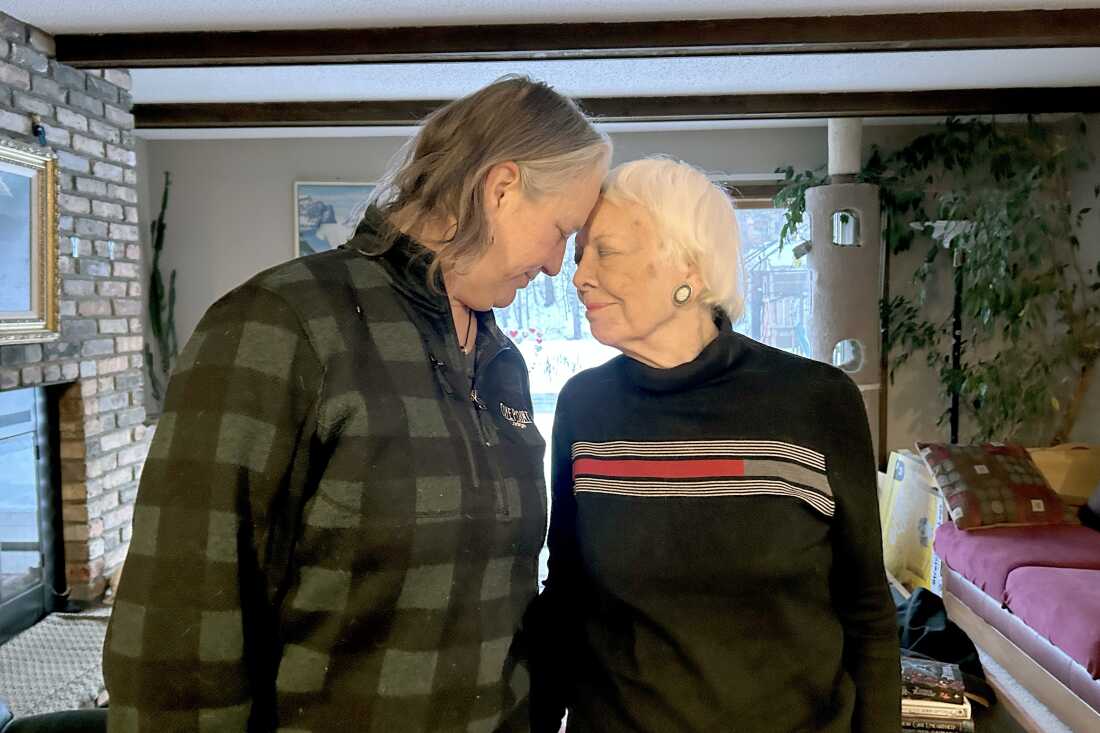 Leaning toward each other, Jacqueline Hamilton (on the left side of the frame) and her mother, Jan Stubbs, (on the right side of the frame) touch foreheads. They are standing inside Hamilton's home in West St. Paul, Minnesota.