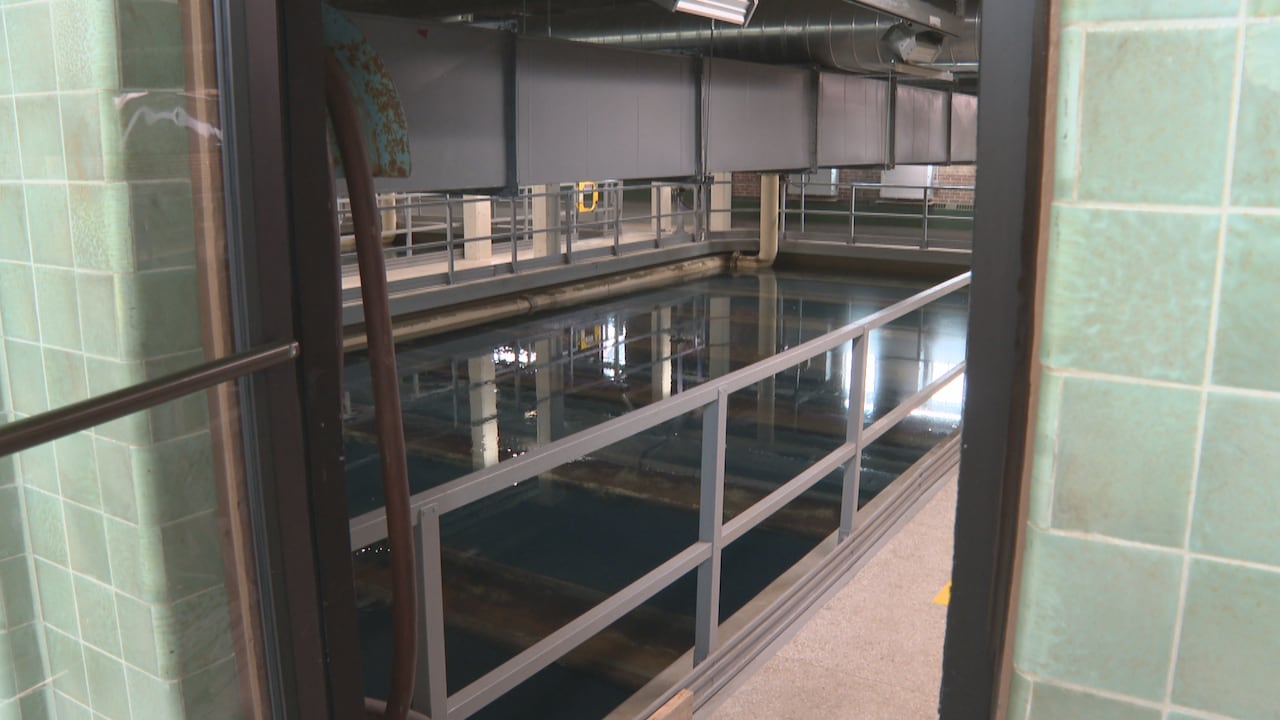 Through a door, there's a pool filled with water. Beneath the surface, you can see several filtration beds lining the pool.