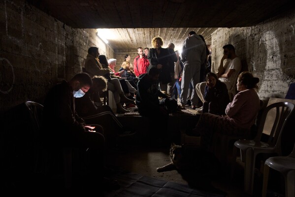 People gather in a bomb shelter as air raid sirens warn of incoming missiles from Iran in Ramat Gan, Israel, Sunday, March 22, 2026. (AP Photo/Oded Balilty)