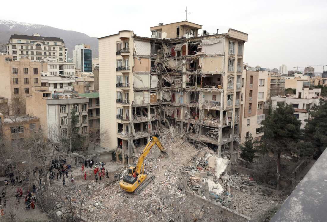 An excavator clears rubble from destroyed residential buildings in northern Tehran, Iran, on Monday, as the U.S. and Israel's war with Iran raged for its fourth week.