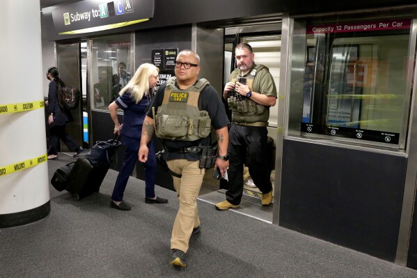 Federal agents step off the inter-terminal subway as they prepare to leave the George Bush Intercontinental Airport and transfer over to Hobby Airport Monday, March 23, 2026, in Houston. (AP Photo/Michael Wyke)