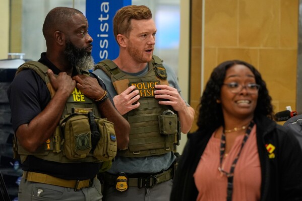 Federal immigration agents are seen at the Hartsfield-Jackson Atlanta International Airport, Monday, March 23, 2026, in Atlanta. (AP Photo/Mike Stewart)