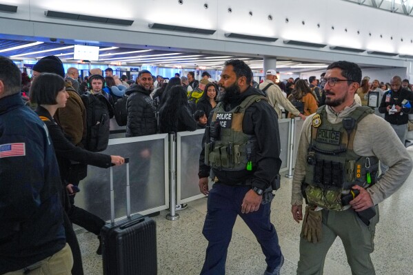 Federal immigration agents walk through Terminal 5 at John F. Kennedy International Airport (JFK) in the Queens borough of New York, Monday, March 23, 2026. (AP Photo/Ryan Murphy)