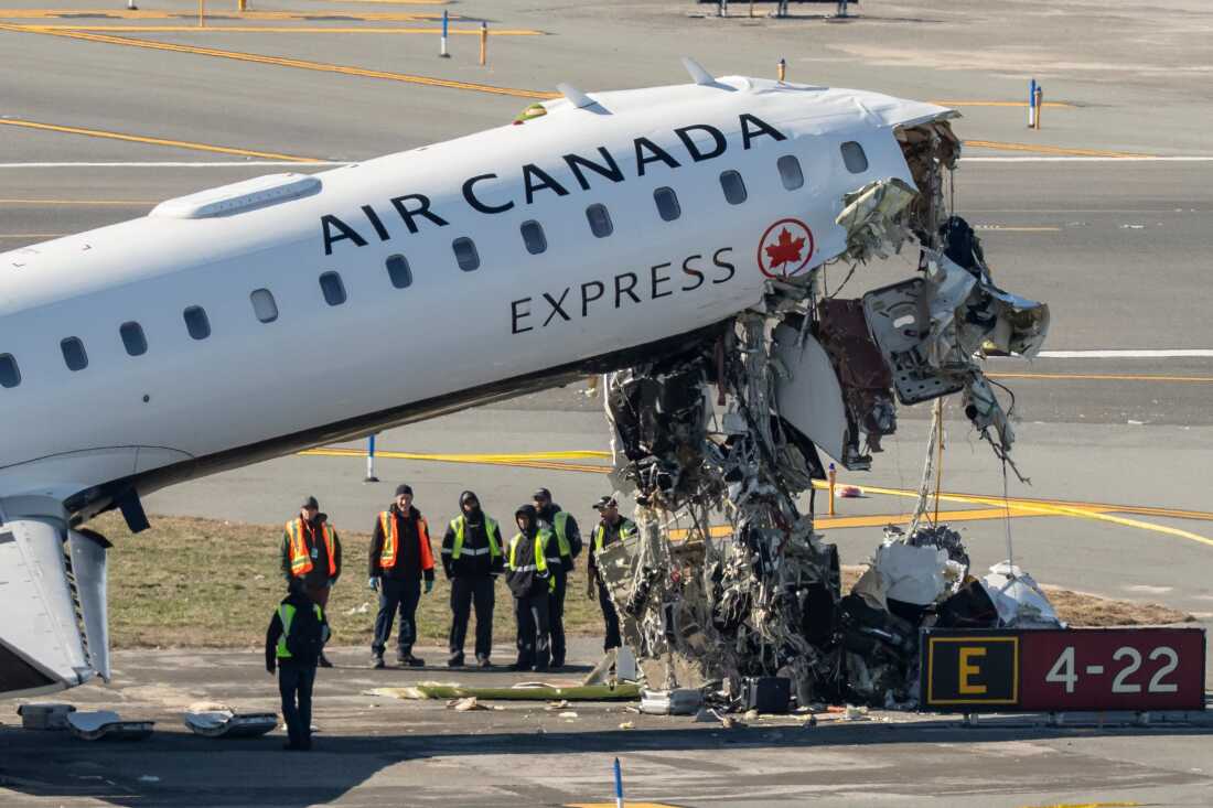 Aircraft maintenance workers inspect the wreckage of an Air Canada Express jet, Tuesday, March 24, 2026, just off the runway where it collided with a Port Authority fire truck Sunday night at LaGuardia Airport in New York. 