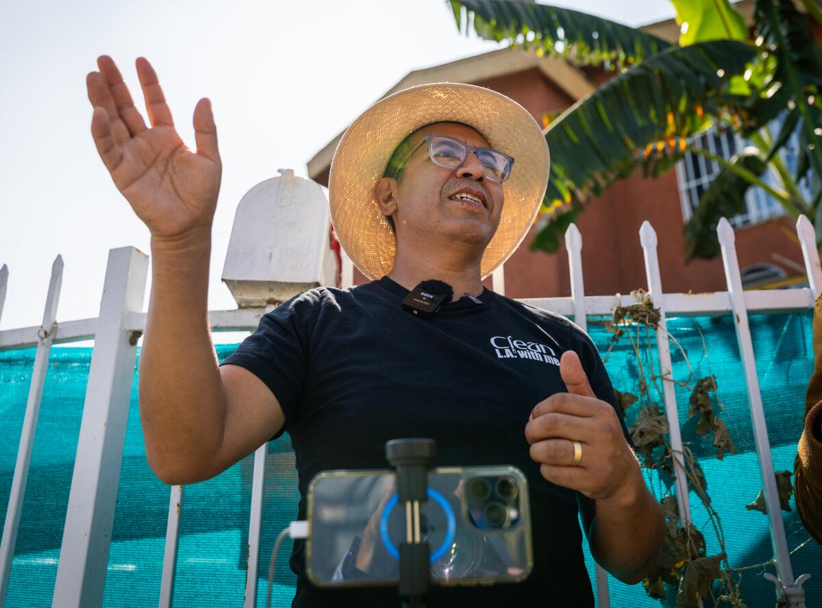 Juan Naula speaks in front of a phone.