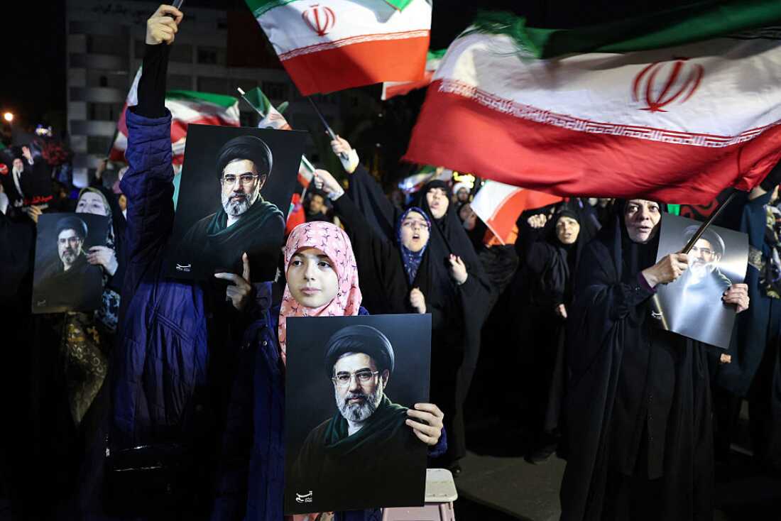 People wave national flags and hold portraits of Iran's supreme leader Mojtaba Khamenei as they march in support of the Iranian armed forces in central Tehran on March 25, 2026.