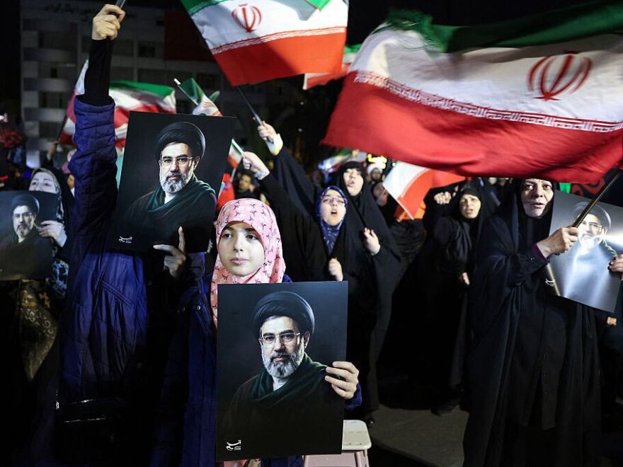 People wave national flags and hold portraits of Iran's supreme leader Mojtaba Khamenei as they march in support of the Iranian armed forces in central Tehran on March 25, 2026.