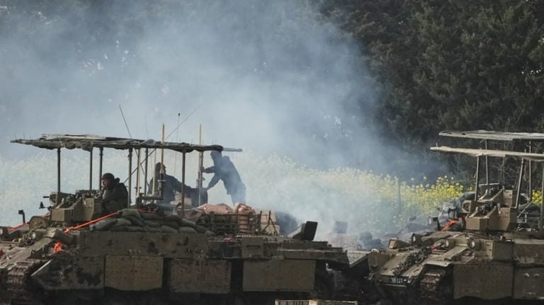 Israeli soldiers atop an APC in northern Israel near the...