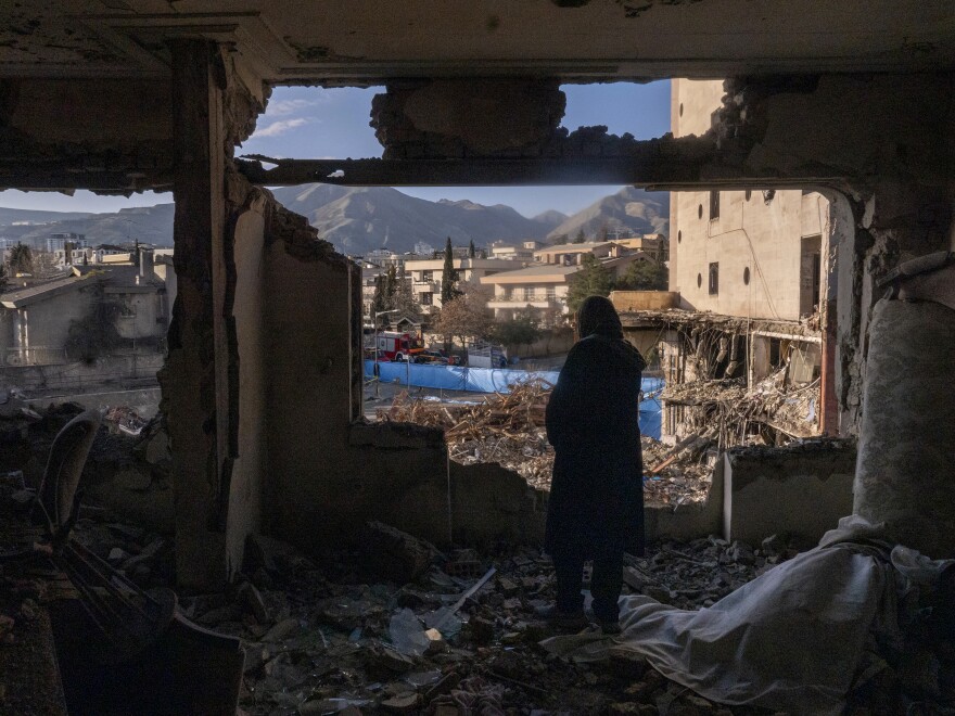 A woman looks out from her destroyed apartment in the remains of a residential and commercial building in the Shahrak-e Gharb neighborhood of Tehran, Iran, on March 21. The building was hit on March 16 amid U.S. and Israeli attacks and resulted in several deaths.