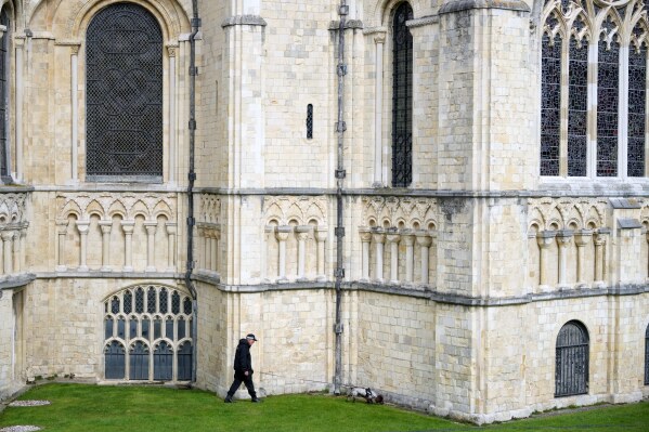 A police officer searches the area with his dog before the installation of Sarah Mullally as archbishop of Canterbury at the Cathedral in Canterbury, England, Wednesday, March 25, 2026, the first woman ever to lead the Church of England. (AP Photo/Alastair Grant)