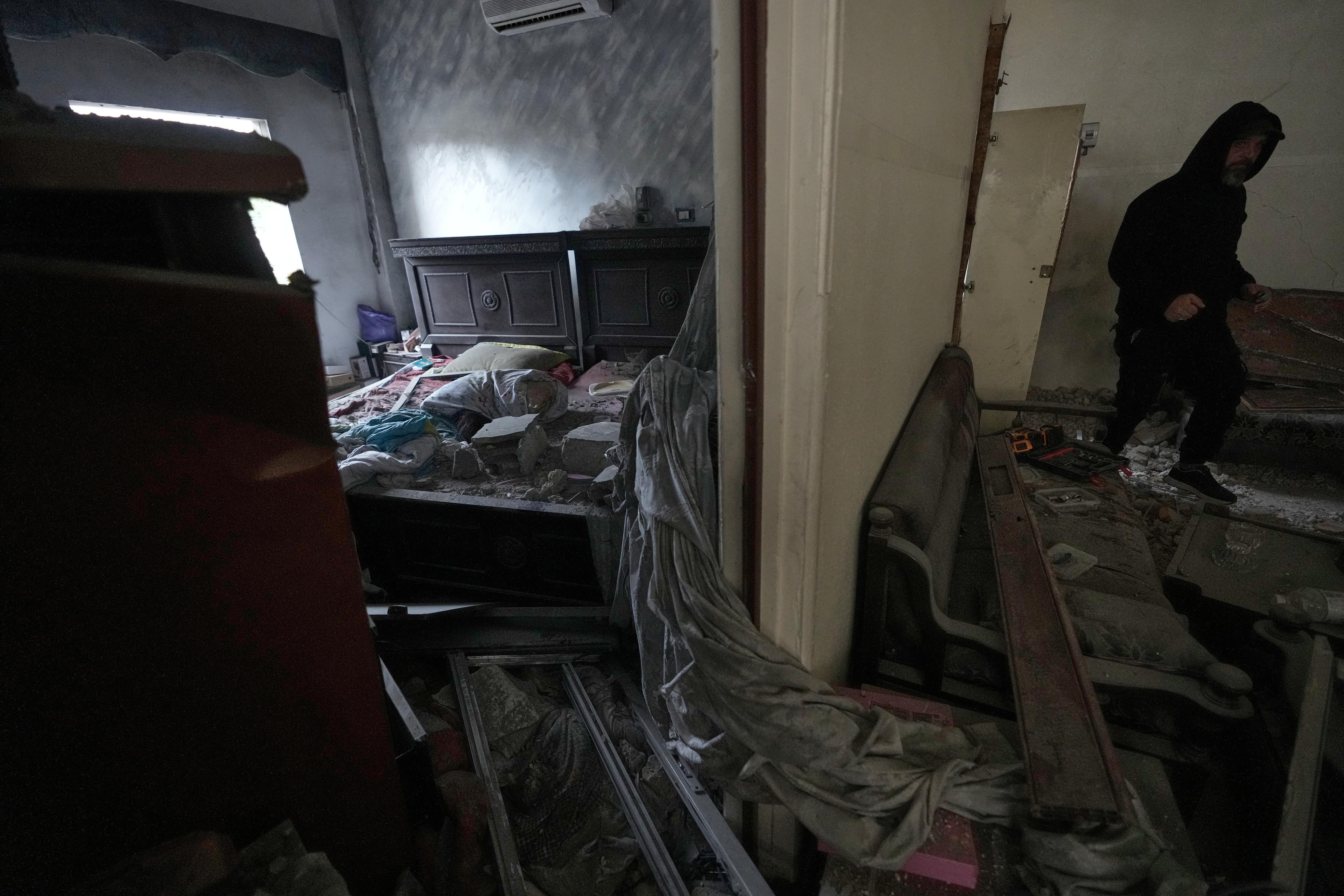 A man checks his damaged apartment at the site of...