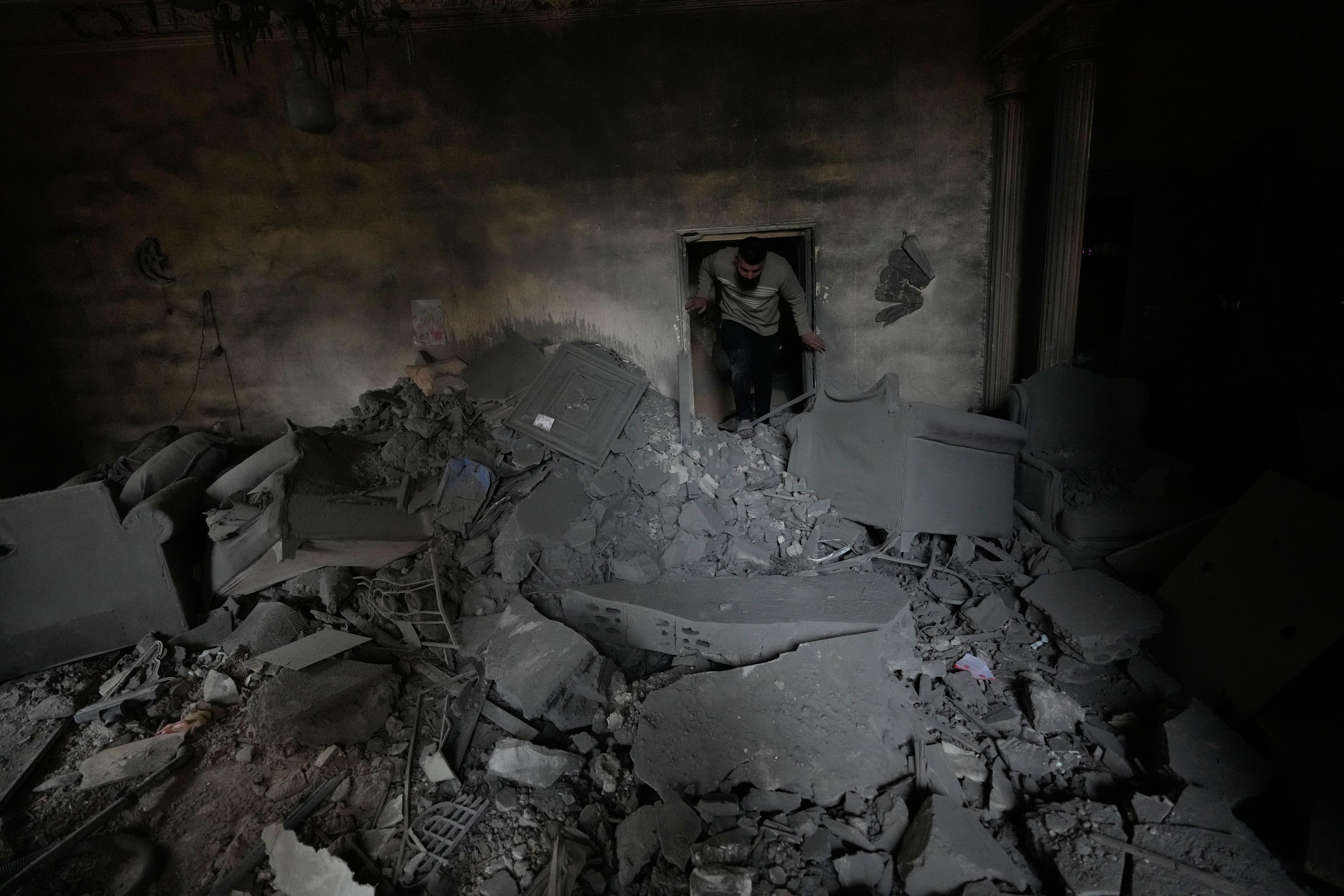 A man checks his damaged apartment at the site of...